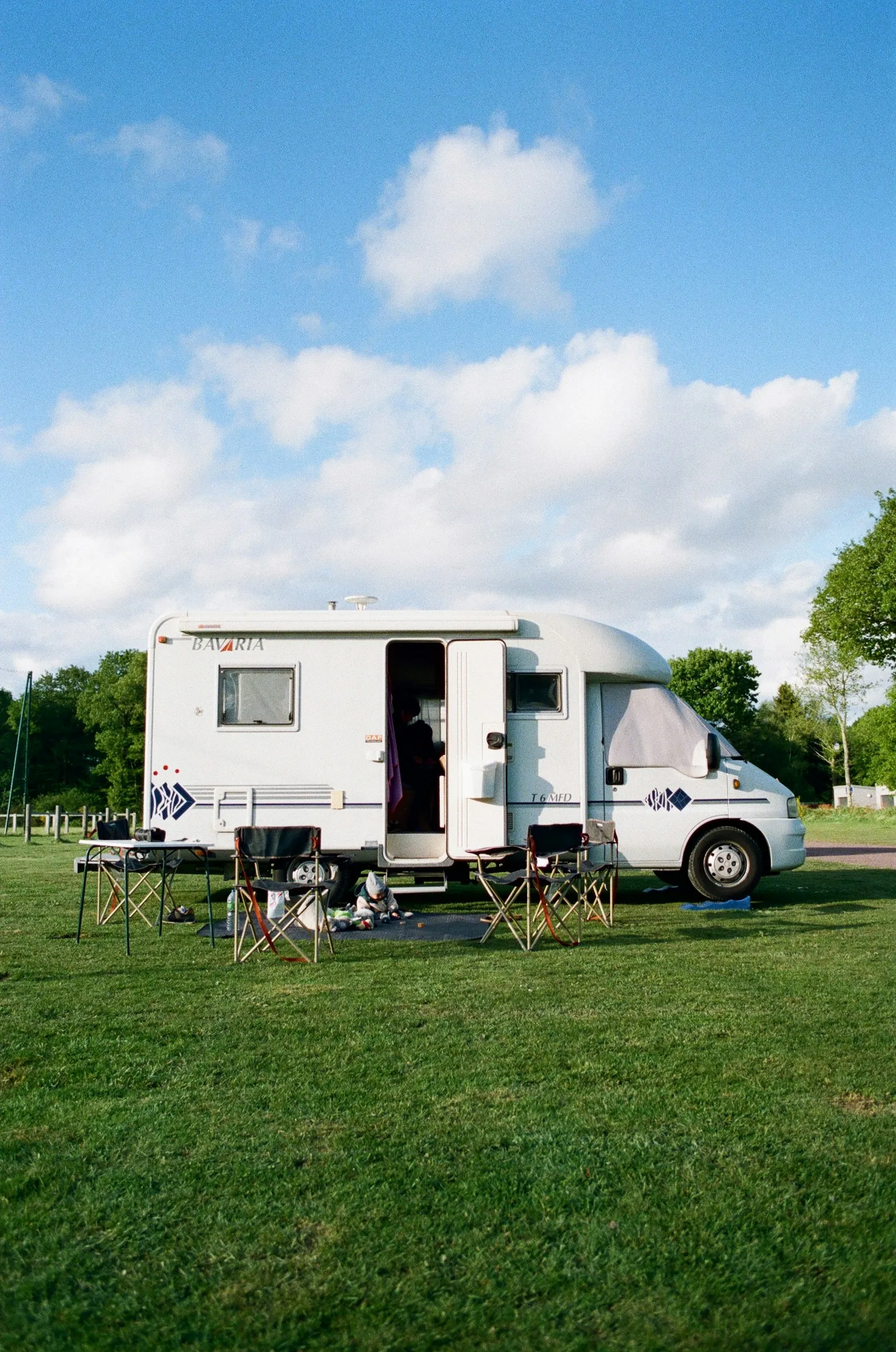 A motorhome set up at a grassy campsite