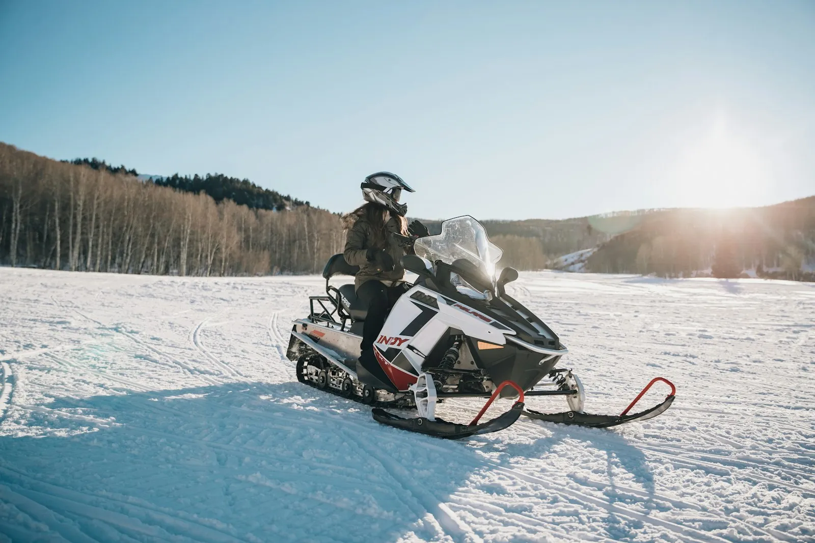 A rider on a snowmobile crossing fresh snow