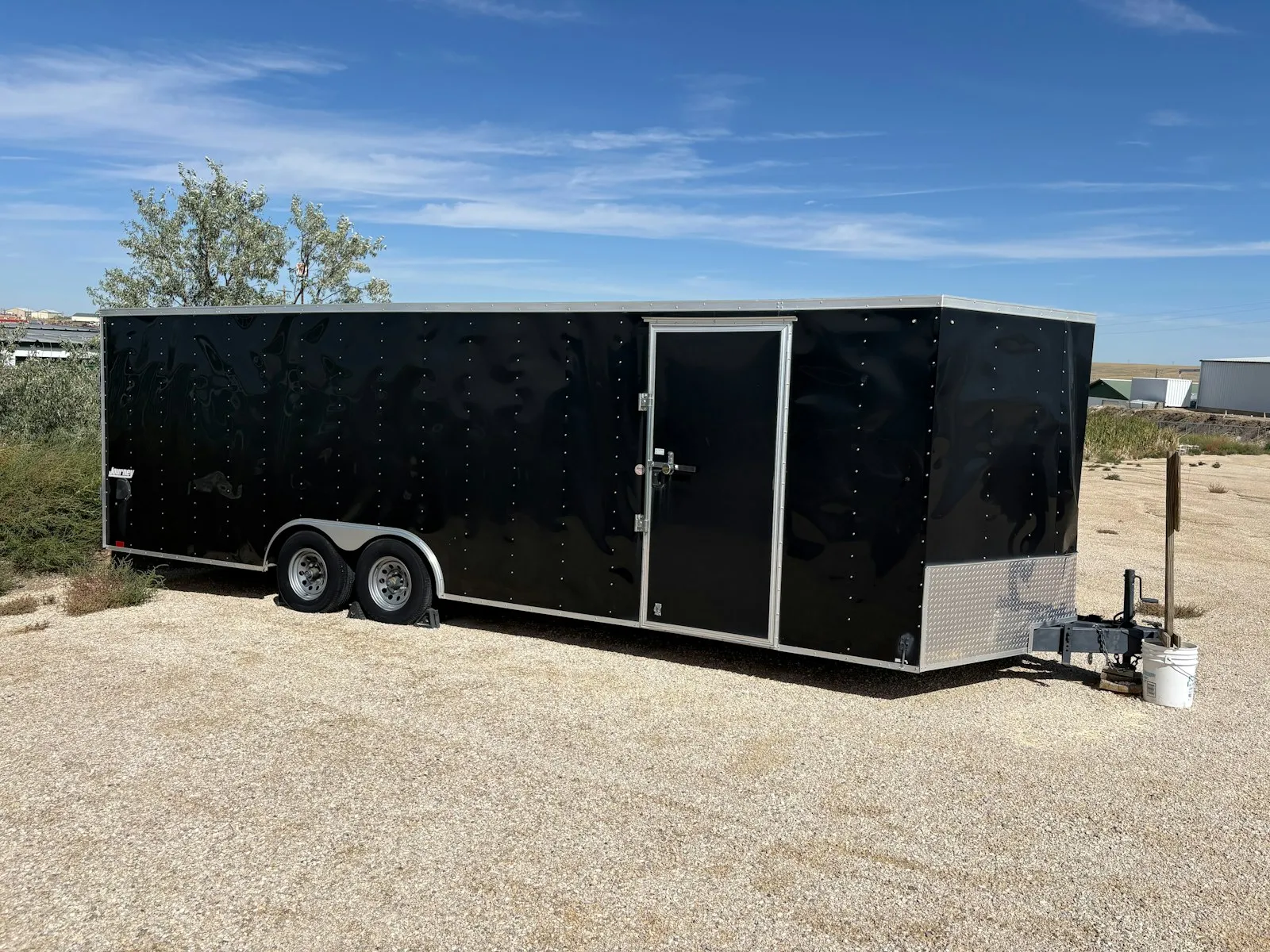 An enclosed cargo trailer parked on gravel